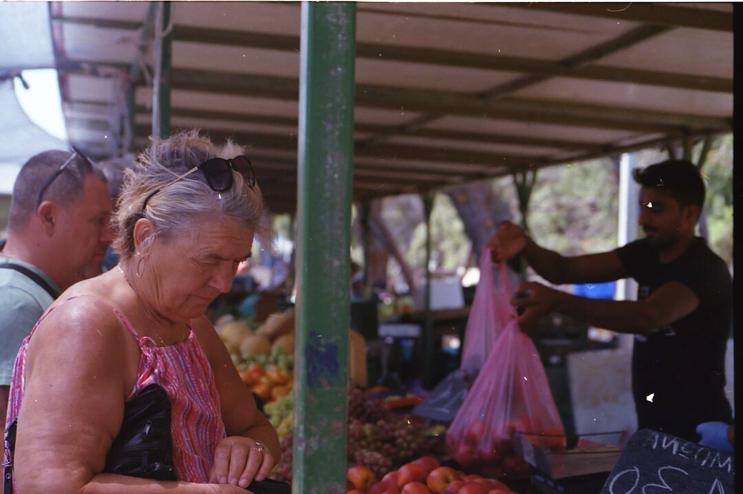 Croatian market vendor arranging fresh vegetables at a stall