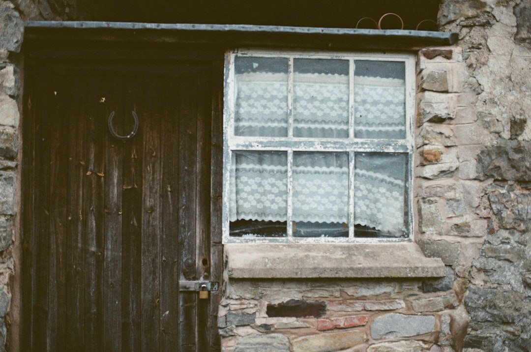 Elderly Croatian woman standing in the doorway of a stone house on a Dalmatian island
